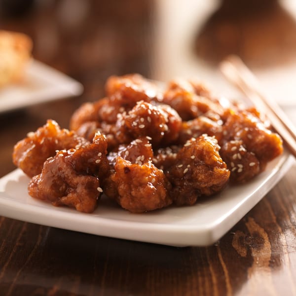 The Dragon Asian Kitchen's sesame chicken, glistening with sauce and sprinkled with sesame seeds.